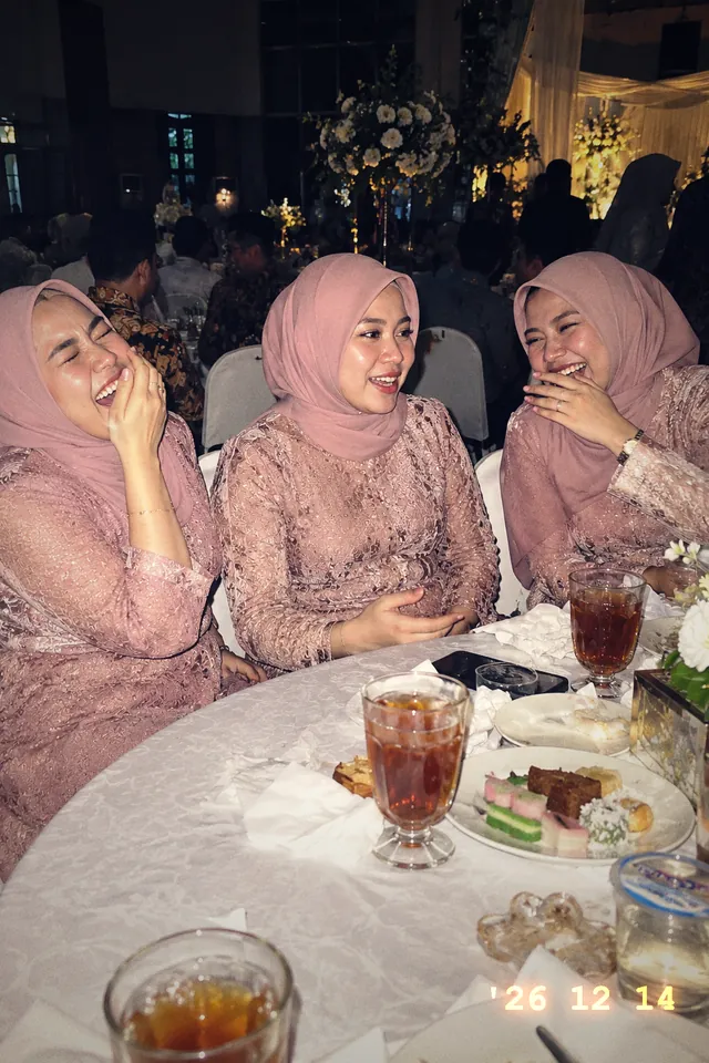 Tiga sahabat Nadia tertawa di meja tamu, Lampu Kilat